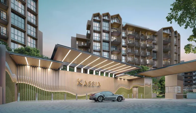 Kassia, artist’s impression: the Arrival Court at dusk, a long canopy with lit ribs over the drive and a curving slatted screen bearing the Kassia name, with a block rising behind